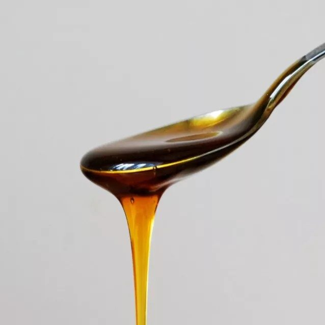Aceite viscoso cayendo de una cuchara – ejemplo de viscosidad alta