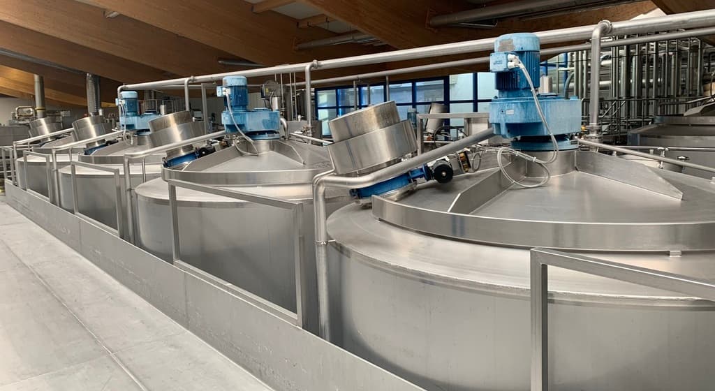 Serbatoi di miscelazione isolati in acciaio inox con agitatore nella produzione alimentare industriale