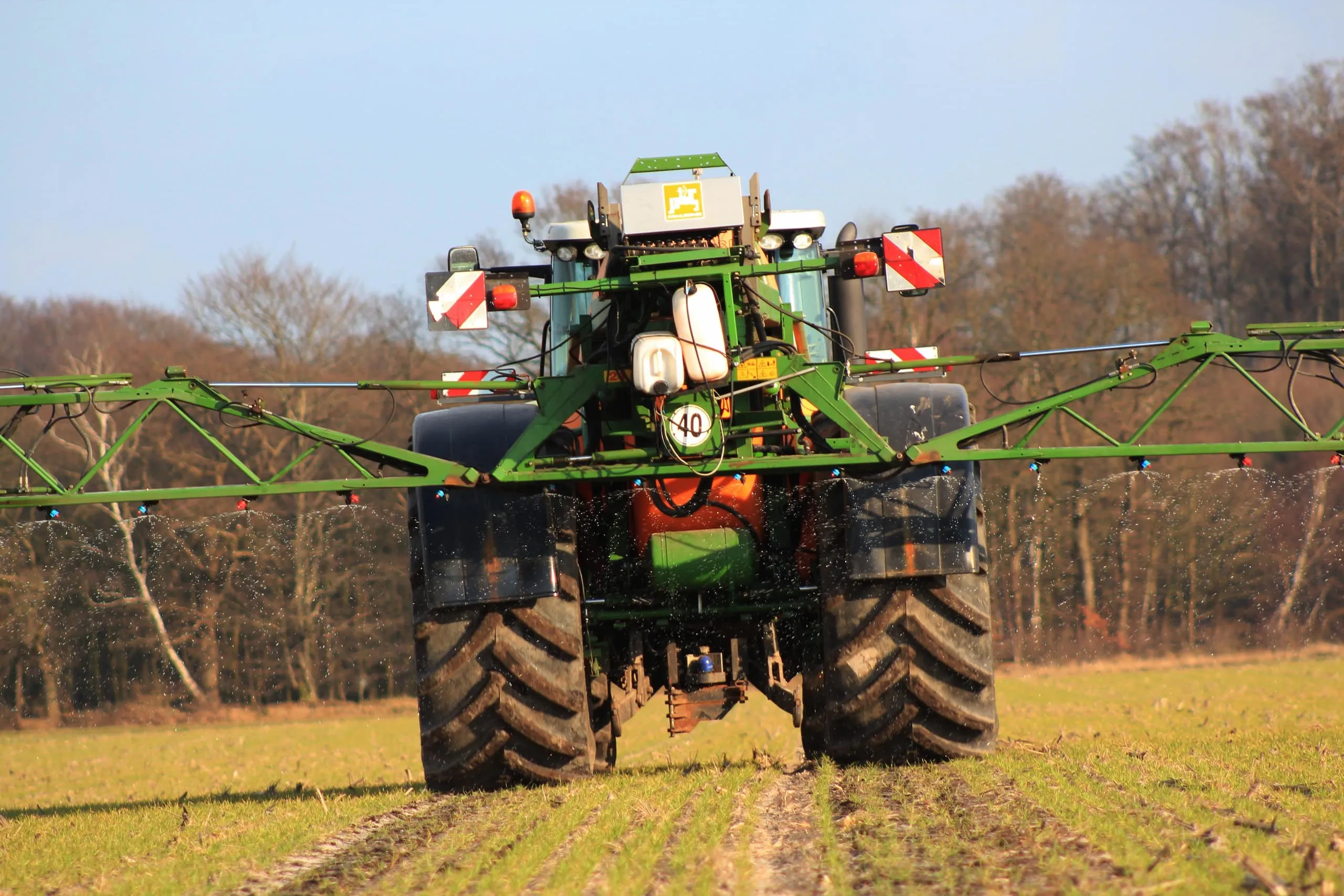Tractor with field sprayer applying AHL liquid fertiliser on arable land